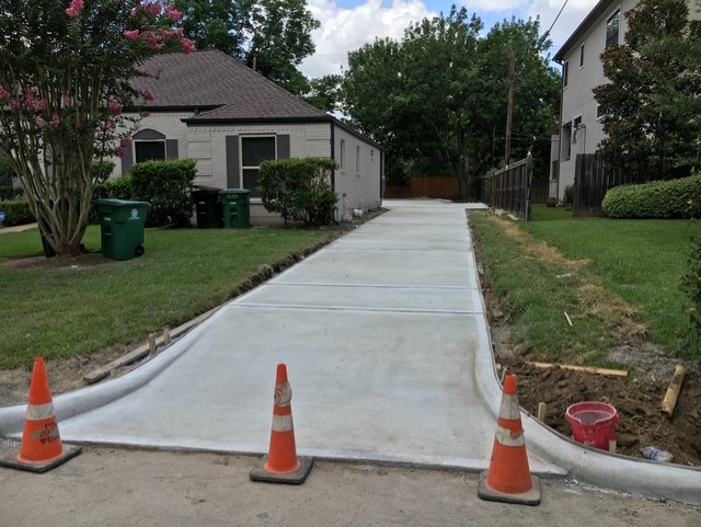Newly finished residential concrete driveway with fresh curb work